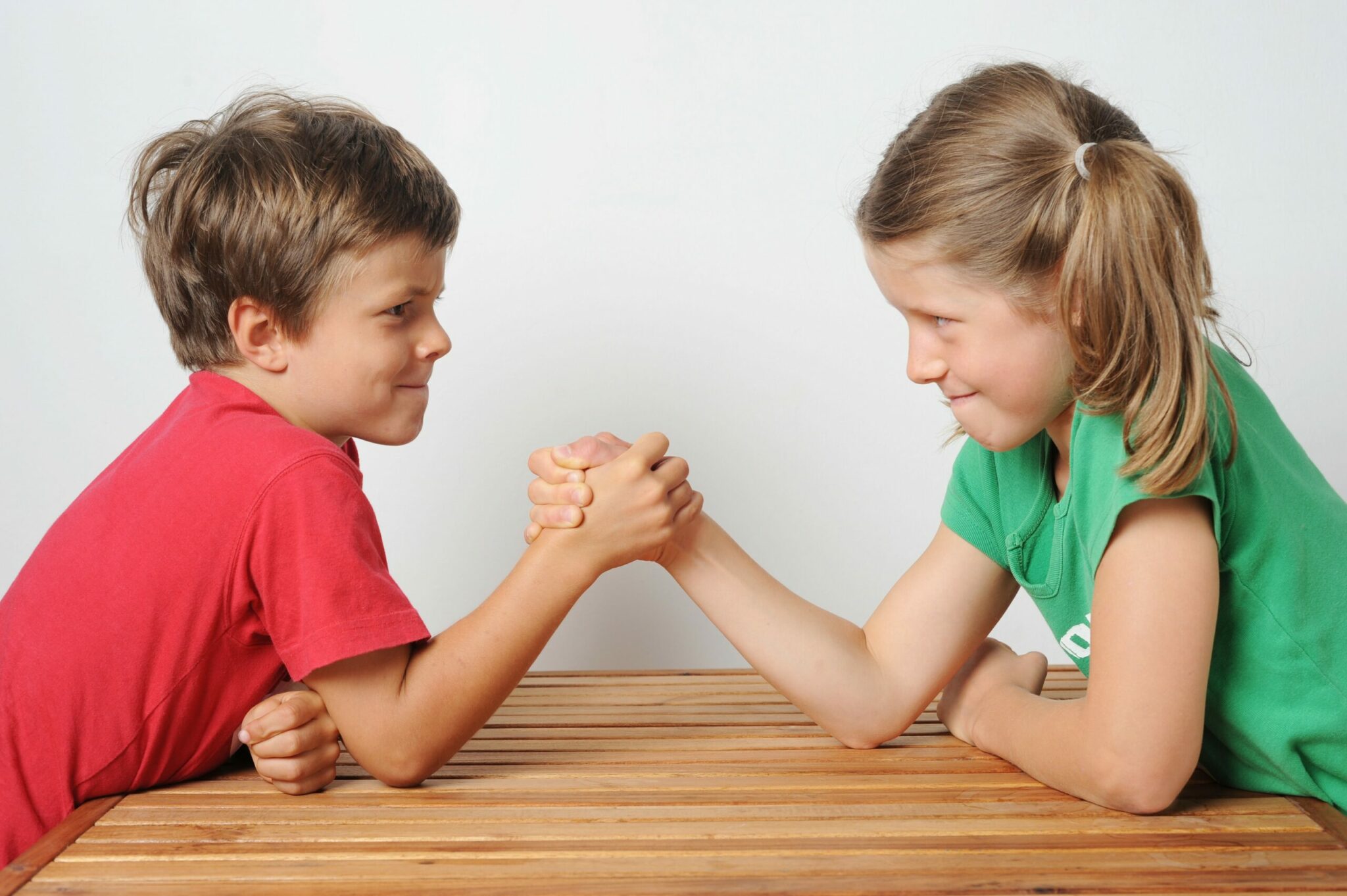Two kids, a boy and a girl, engaged in a heated argument at a table.