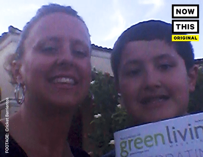 A woman and a boy holding up a green living magazine, showcasing the benefits of the Teach Kids feature offered by the BusyKid app. This interactive app empowers children to learn about financial literacy