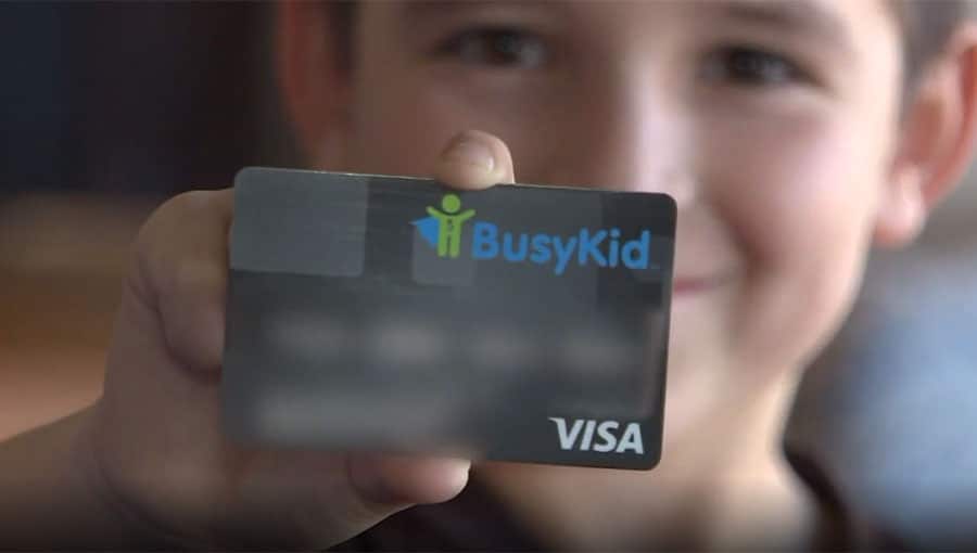 A busykid in New York holding up a card with the word busykid on it.