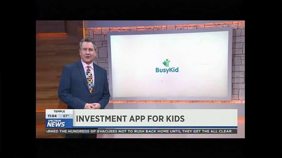 An SN-AUS tv news show with a man in a suit talking about an investment app for kids in Austin, TX.