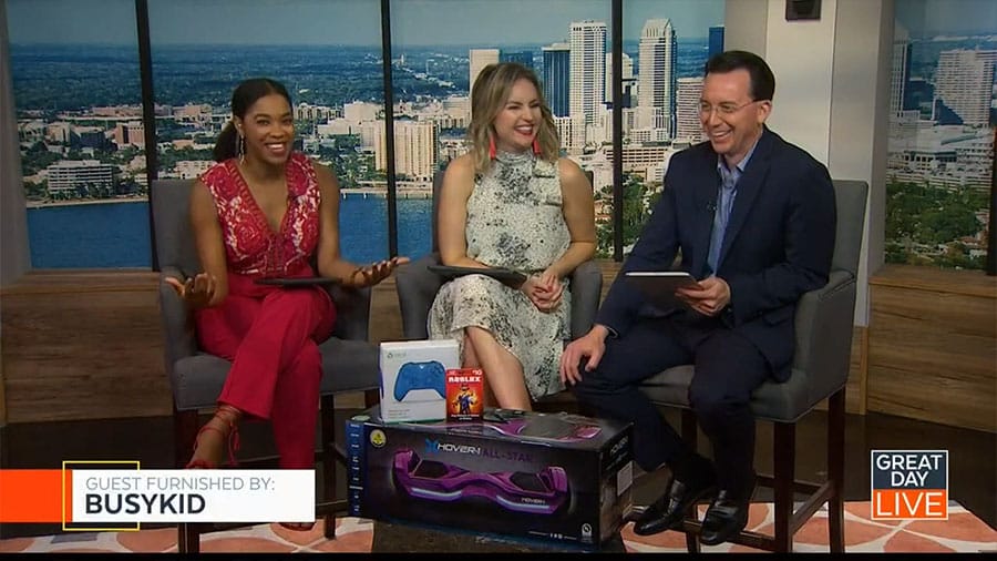 Three people are sitting on a television set in Tampa.