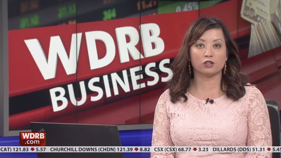 A woman sitting in front of a tv screen with the words wdrb business.