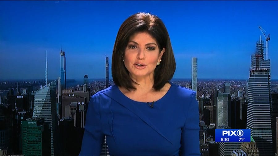 A woman in a blue dress is on the news in New York.