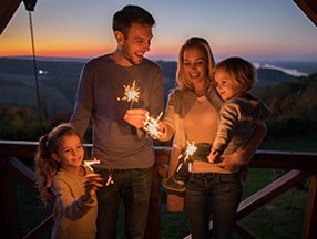 Family celebrating 2021 with sparklers at sunset, pursuing their Financial Goals for a Better future.